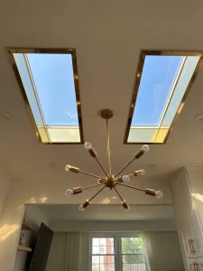 Twin skylights installed in home ceiling with modern light fixture